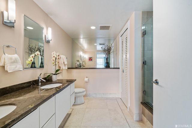 a bathroom with a double vanity sink a mirror and a shower