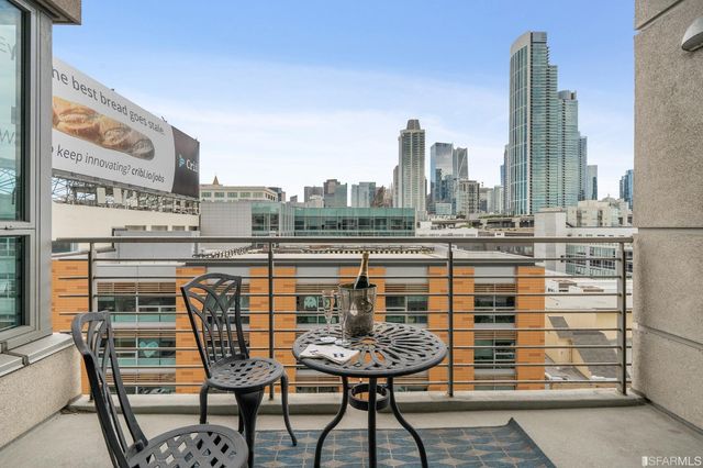 a view of a city from a balcony with furniture