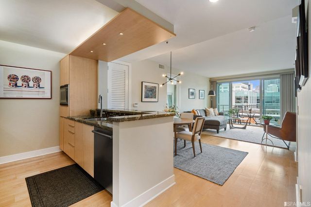 a living room with stainless steel appliances granite countertop furniture a couch and a large window