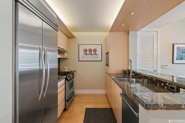 a kitchen with granite countertop a refrigerator and a sink
