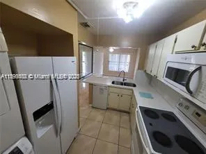 a kitchen with a sink a stove a microwave and cabinets