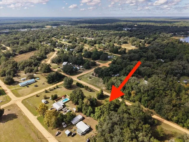a aerial view of a houses with a yard and lake view
