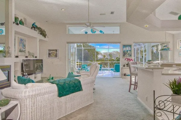 a living room with furniture a chandelier and a floor to ceiling window