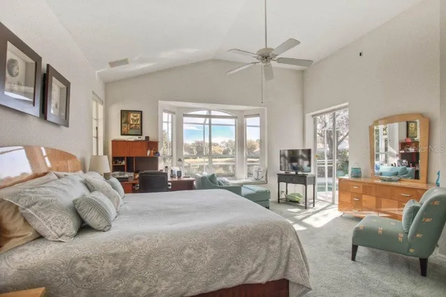 a spacious bedroom with a bed a couch and large window