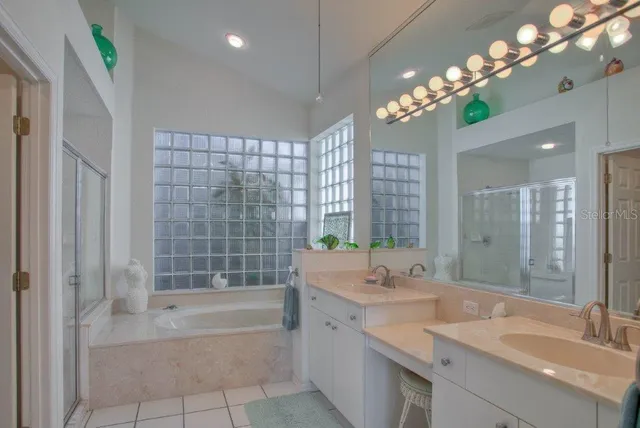 a spacious bathroom with a granite countertop sink a toilet a mirror and shower