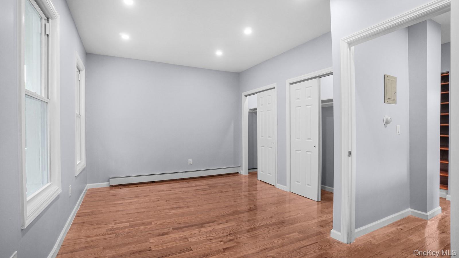 1513 Rosedale Avenue Bronx, NY 10460 - Photo 13 of 29 Unfurnished bedroom with a baseboard heating unit, wood finished floors, recessed lighting, and multiple closets
