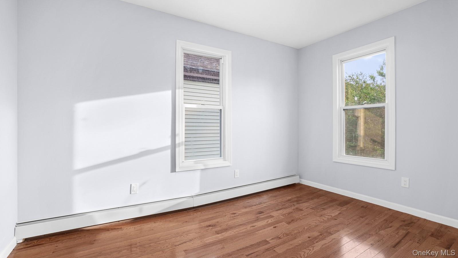 1513 Rosedale Avenue Bronx, NY 10460 - Photo 14 of 29 Spare room featuring a baseboard heating unit and wood finished floors