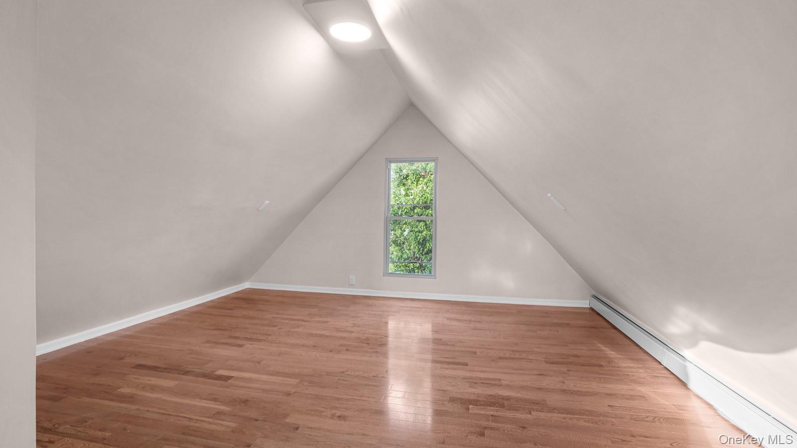 1513 Rosedale Avenue Bronx, NY 10460 - Photo 16 of 29 Bonus room featuring baseboard heating, wood finished floors, and lofted ceiling