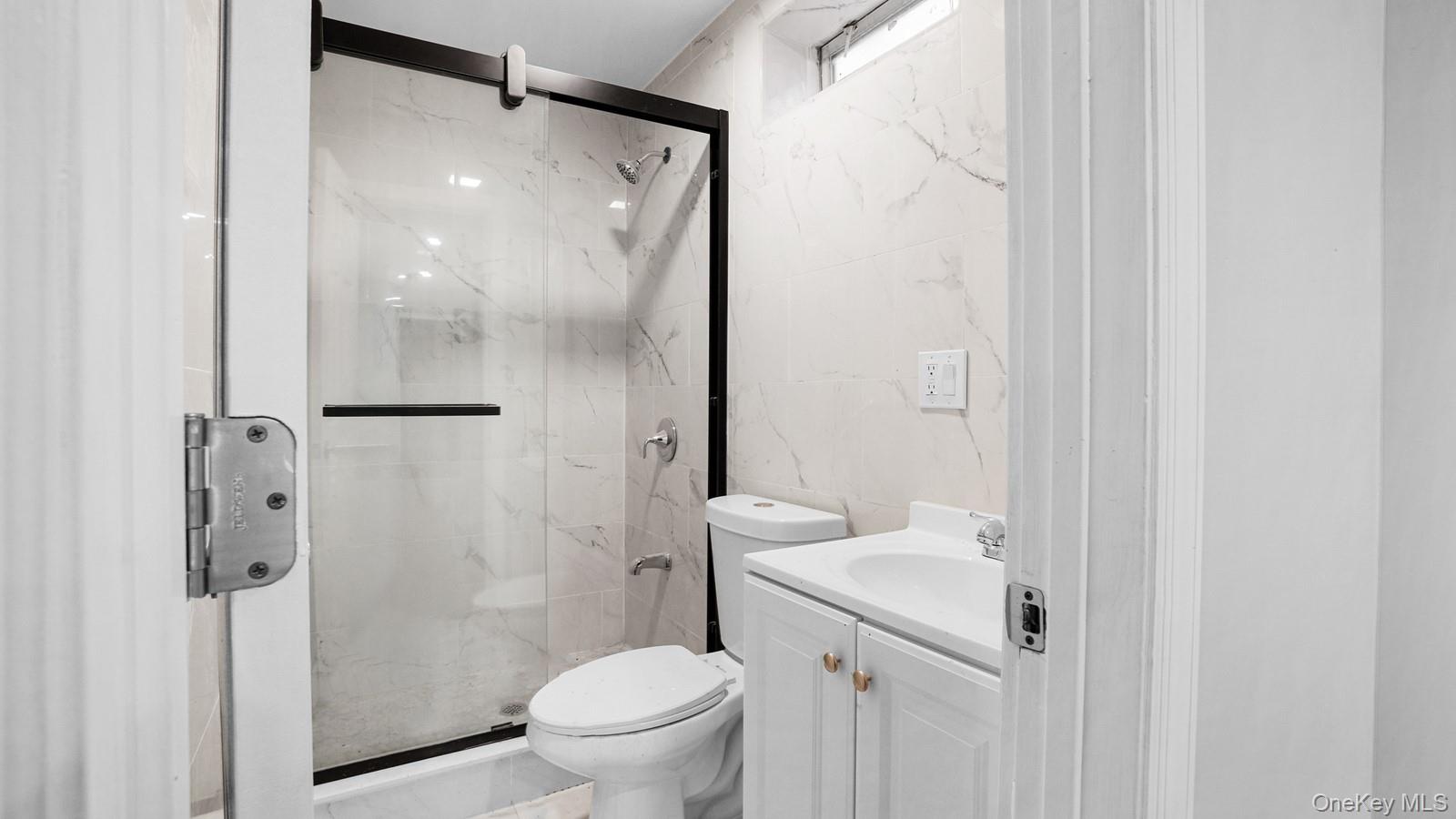 1513 Rosedale Avenue Bronx, NY 10460 - Photo 9 of 29 Full bath with a marble finish shower, tile walls, and vanity
