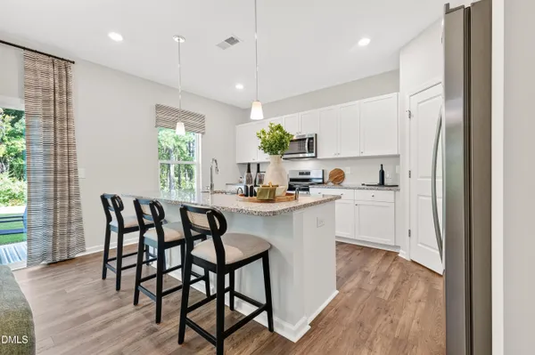 a kitchen with a table chairs refrigerator and microwave