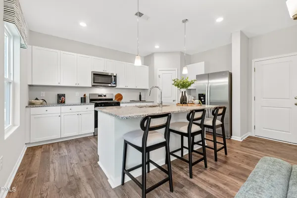 a kitchen with kitchen island granite countertop a table and chairs in it