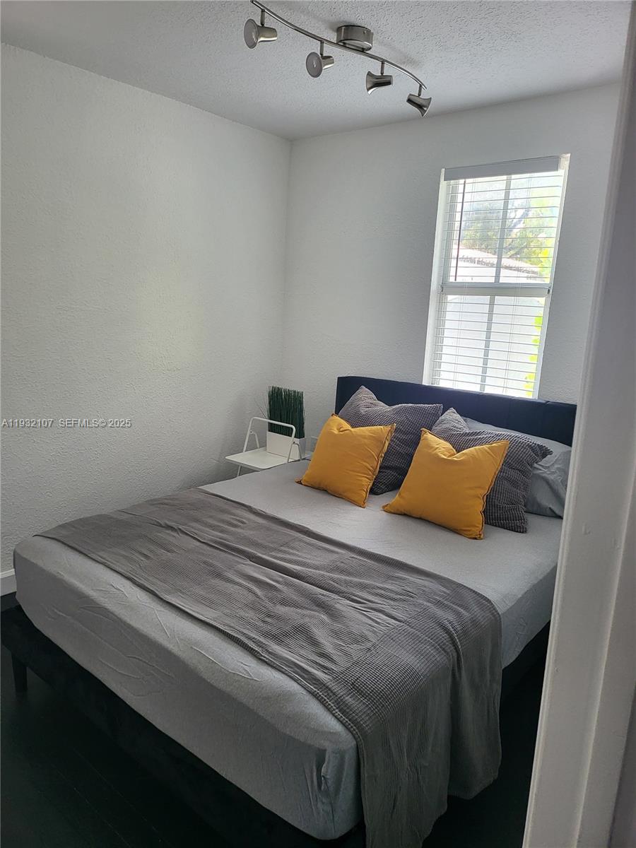 210 Northeast 110th Street Miami, FL 33161 - Photo 13 of 26 a bedroom with a bed and a window