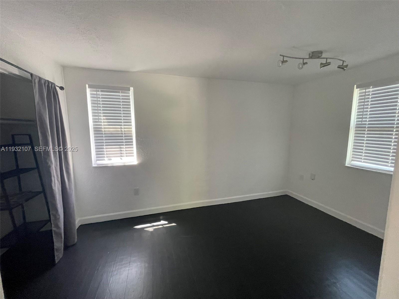 210 Northeast 110th Street Miami, FL 33161 - Photo 14 of 26 an empty room with wooden floor and windows