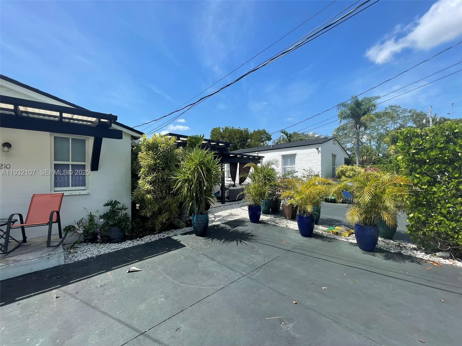 210 Northeast 110th Street Miami, FL 33161 - Photo 4 of 26 a view of a patio with table and chairs under an umbrella