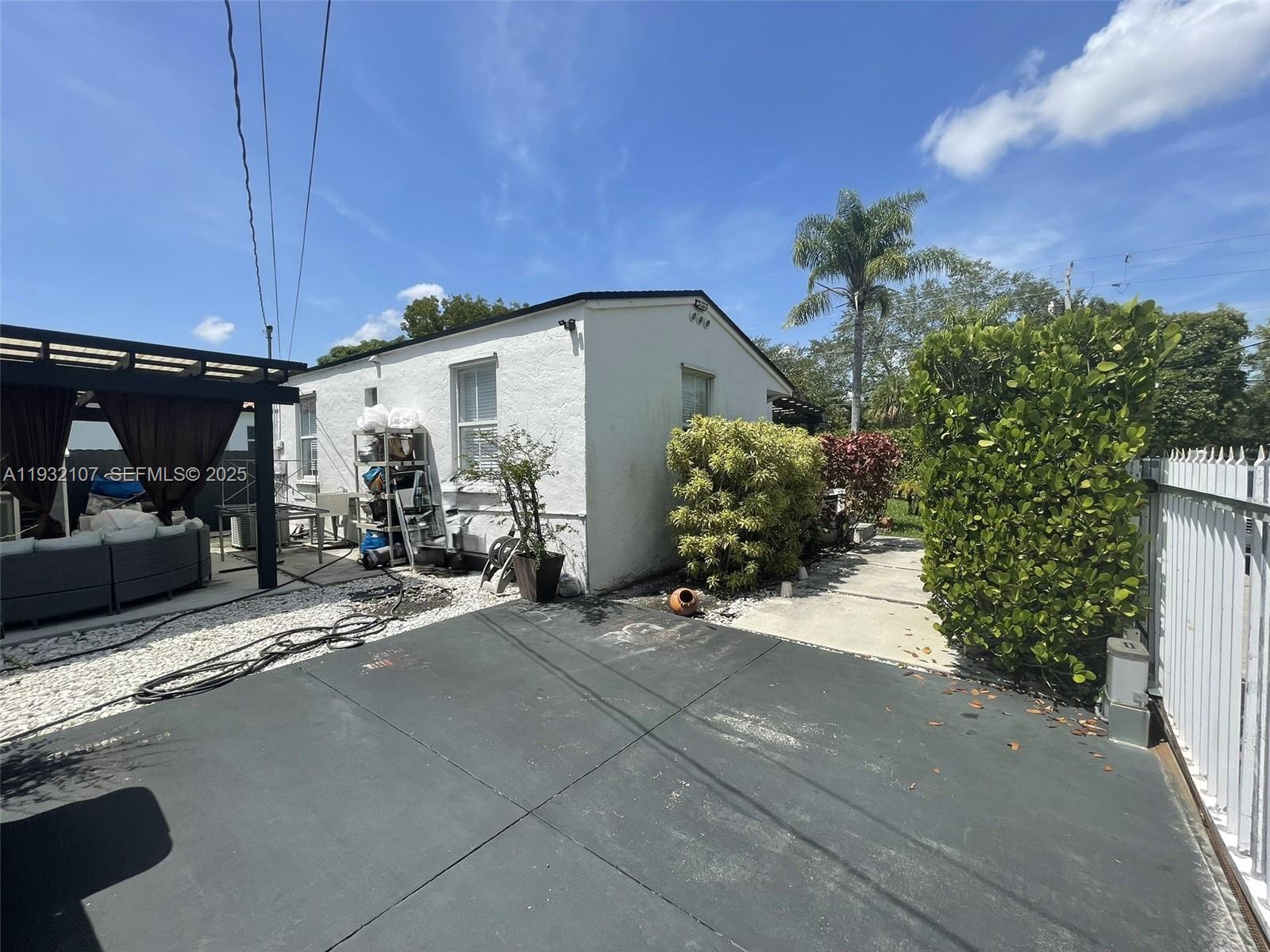 210 Northeast 110th Street Miami, FL 33161 - Photo 5 of 26 a view of a patio with table and chairs under an umbrella