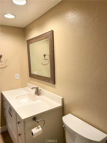 a bathroom with a sink mirror vanity and toilet