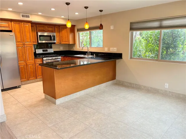 a kitchen with stainless steel appliances granite countertop a stove a sink and a refrigerator