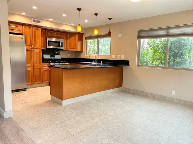 a view of kitchen with kitchen island stainless steel appliances a refrigerator and a counter top space