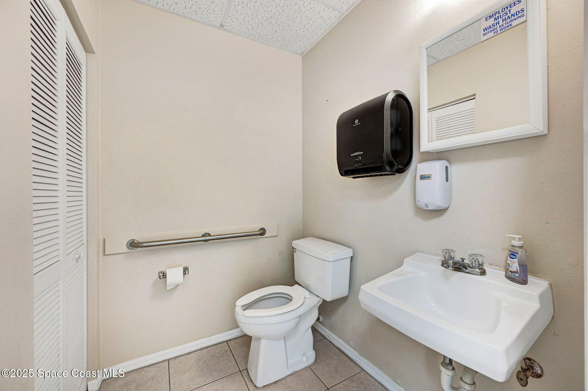 1801 Sarno Road, Unit 5 & 6 Melbourne, FL 32935 - Photo 38 of 44 a bathroom with a toilet sink and mirror