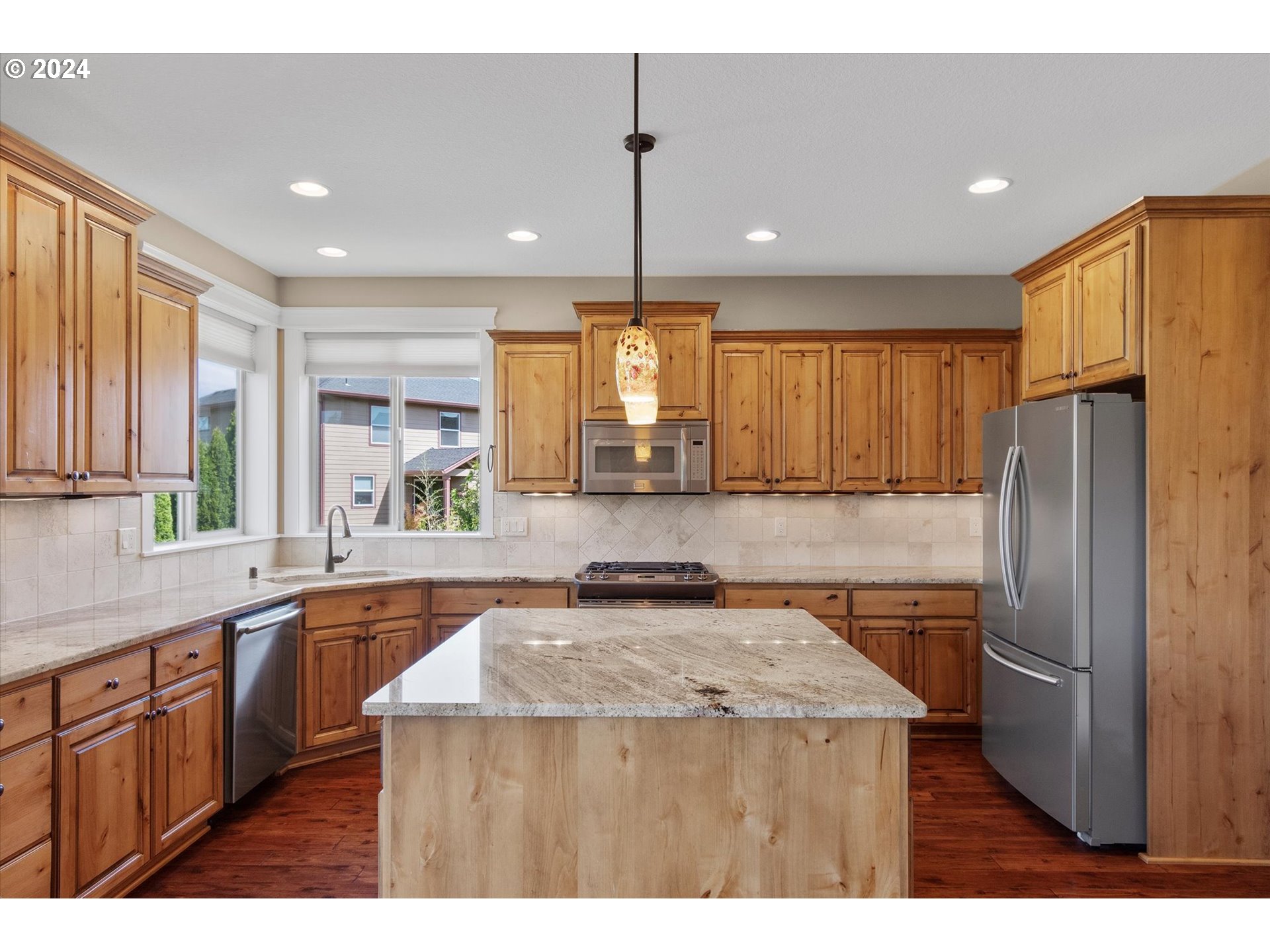 1760 South 18th Circle Ridgefield, WA 98642 - Photo 13 of 36 a kitchen with stainless steel appliances granite countertop a refrigerator a sink dishwasher a stove with wooden cabinets and floor