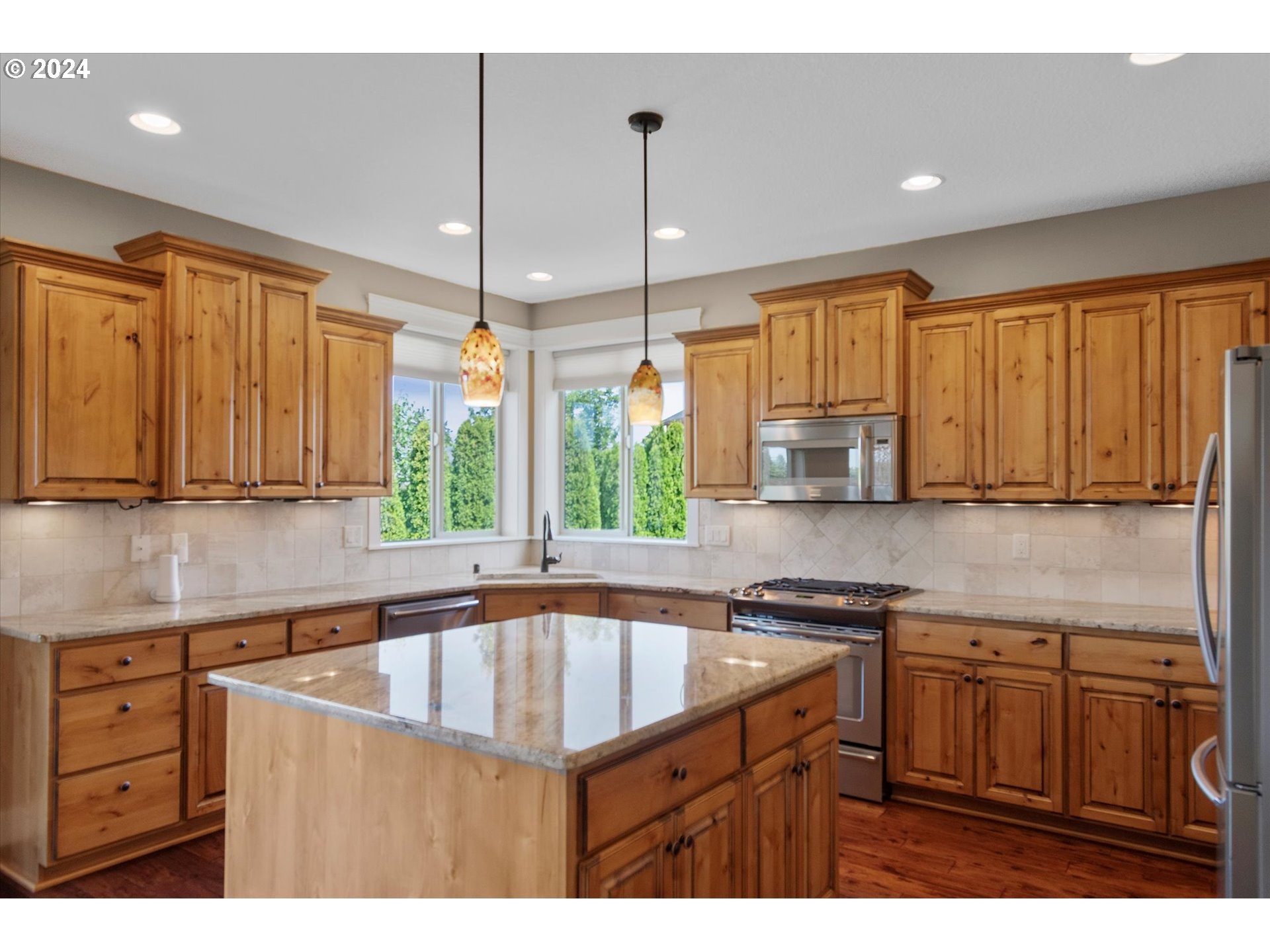 1760 South 18th Circle Ridgefield, WA 98642 - Photo 14 of 36 a kitchen with kitchen island granite countertop a sink window and cabinets