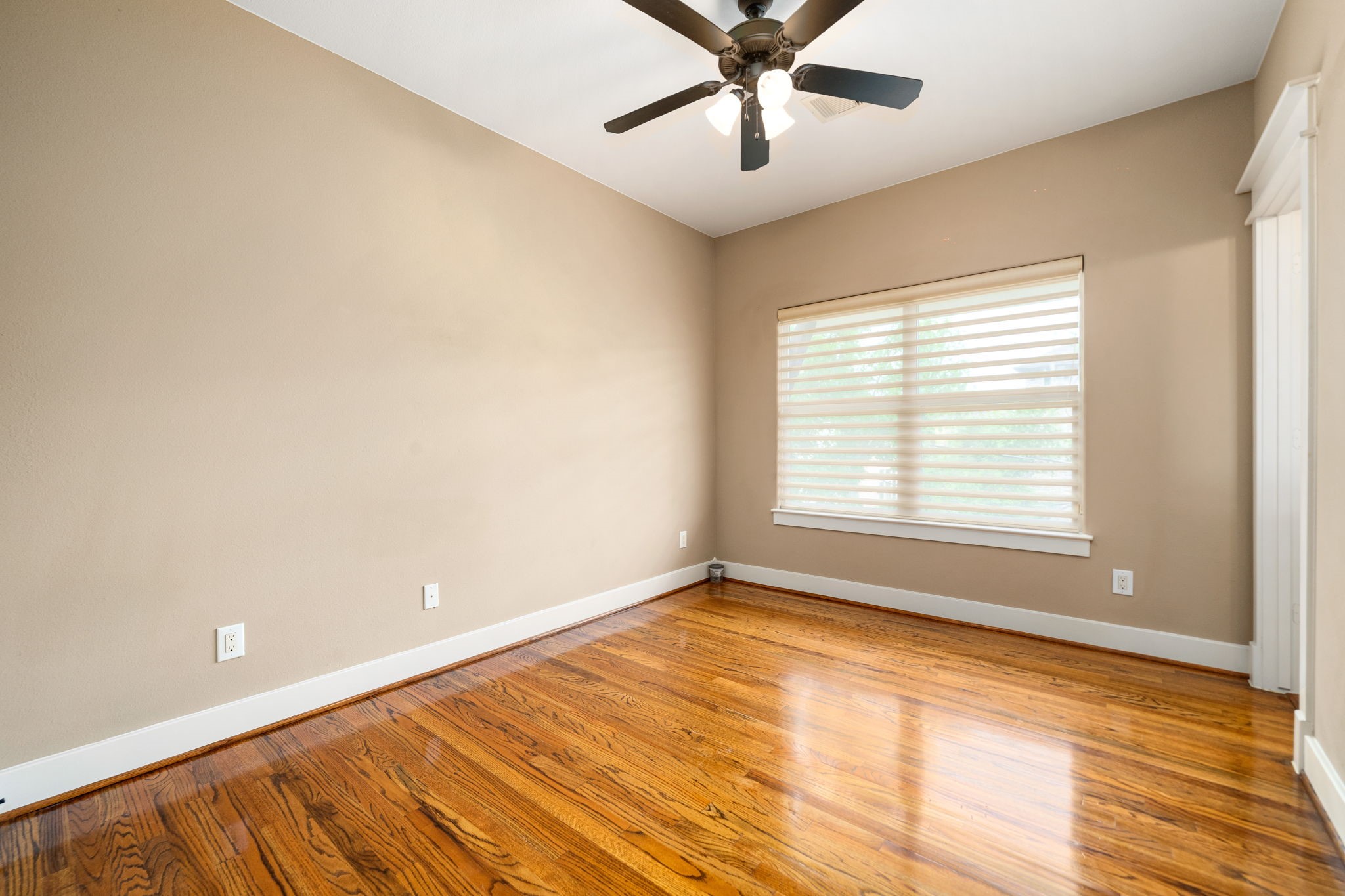 229 Knox Street Houston, TX 77007 - Photo 25 of 33 a view of an empty room with a window and wooden floor