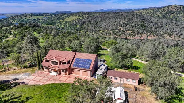 an aerial view of a house with a yard and lake view