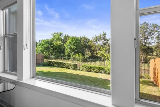 a view of a room that has a large window and a yard