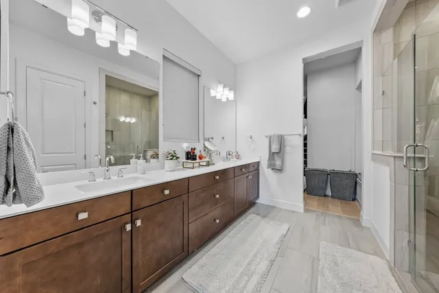 a spacious bathroom with a double vanity sink a mirror and a bathtub