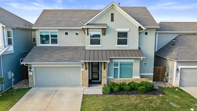 a front view of a house with yard and glass windows