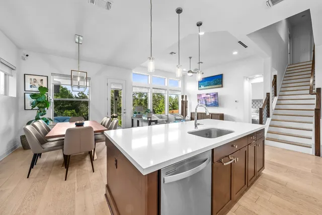a kitchen with a sink a counter top space and living room view