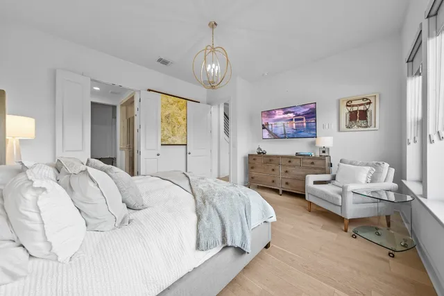 a bedroom with bed and a chandelier