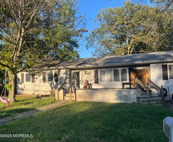 a view of a yard with table and chairs under an umbrella