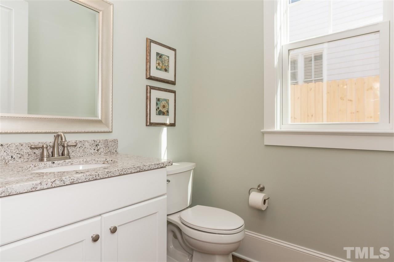 2619 Davis Street Raleigh, NC 27608 - Photo 11 of 25 a bathroom with a granite countertop toilet a sink and a window
