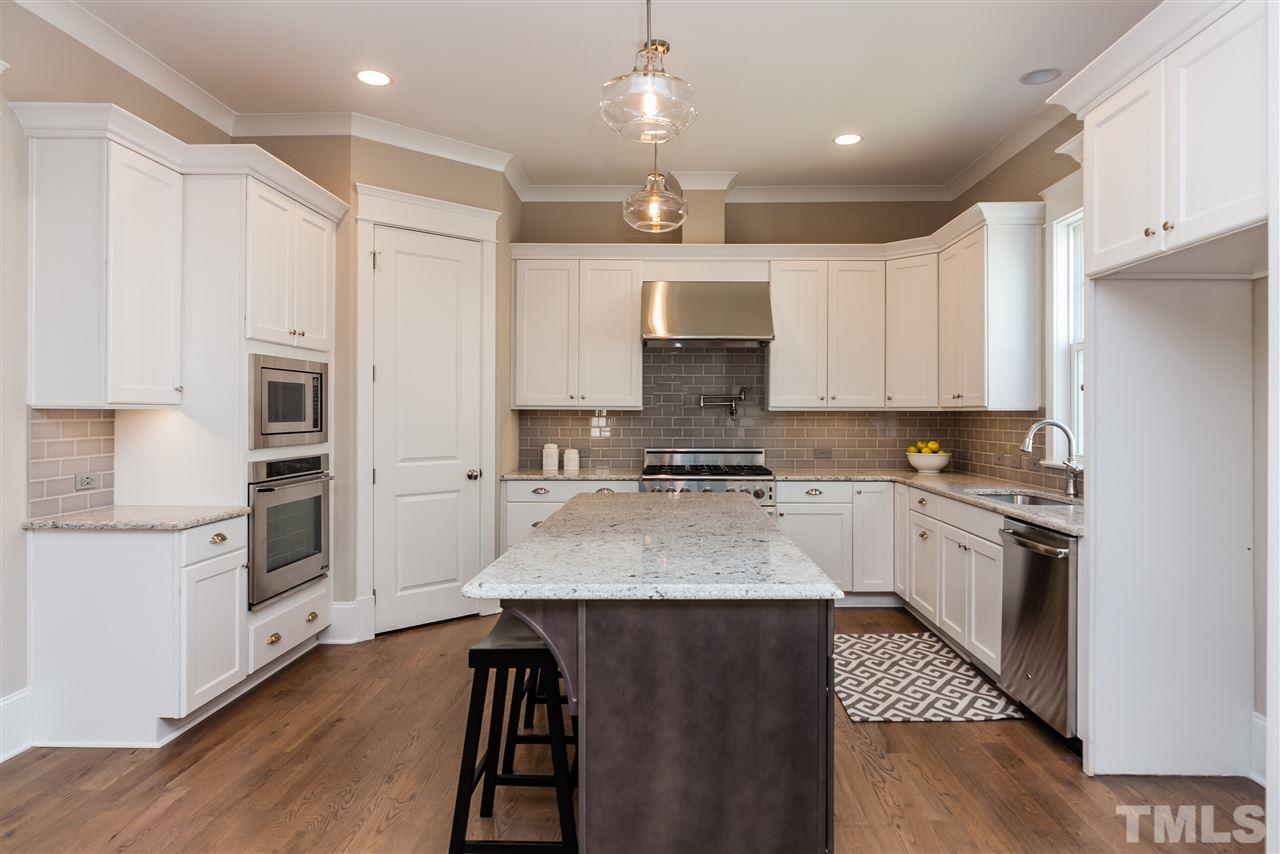 2619 Davis Street Raleigh, NC 27608 - Photo 8 of 25 a large kitchen with stainless steel appliances kitchen island granite countertop a stove a sink dishwasher and a refrigerator with wooden floor