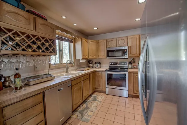 a kitchen with stainless steel appliances granite countertop a stove a sink and a refrigerator