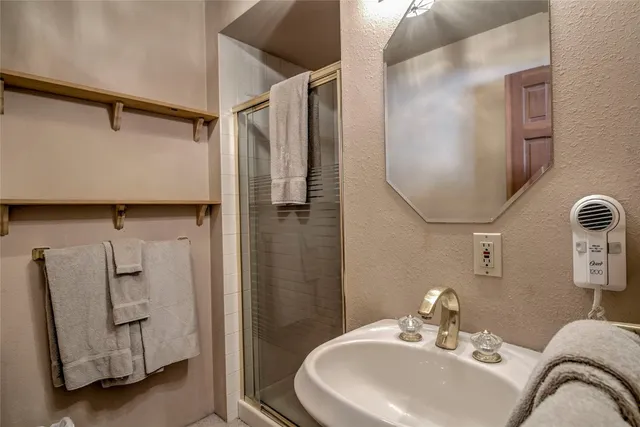 a bathroom with a sink a mirror and shower
