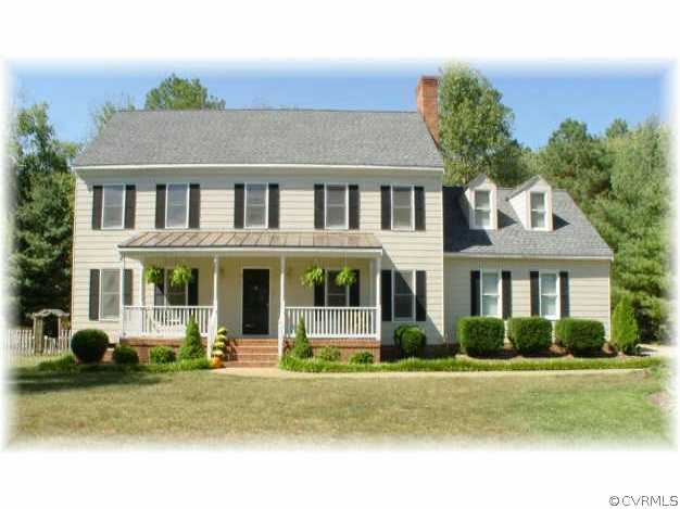 a front view of a house with garden and plants