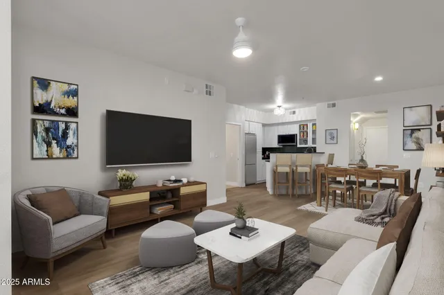 a living room with furniture kitchen view and a flat screen tv