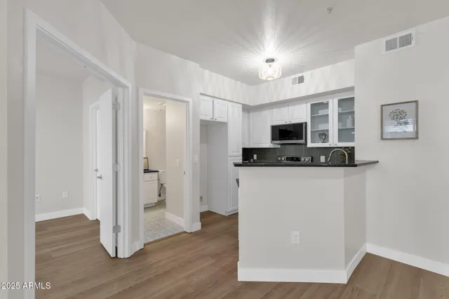 a view of kitchen with stainless steel appliances wooden floor and wooden cabinets