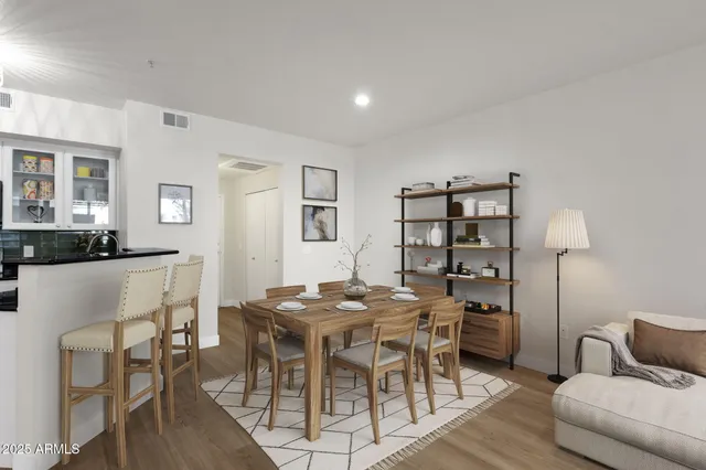 a view of kitchen with stainless steel appliances granite countertop a refrigerator a stove top oven a wooden floor and cabinets