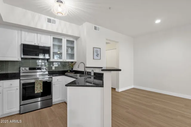 a view of a kitchen with wooden floor and a refrigerator