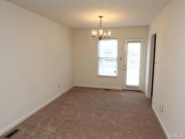 8201 Bellingham Circle Raleigh, NC 27615 - Photo 13 of 22 an empty room with a chandelier fan and windows