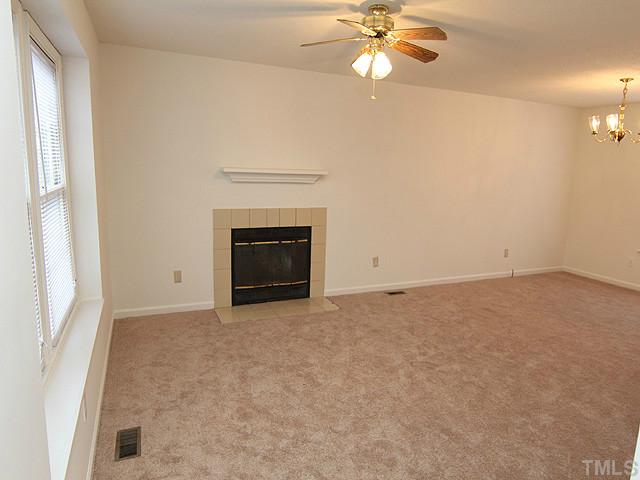 8201 Bellingham Circle Raleigh, NC 27615 - Photo 3 of 22 an empty room with a fireplace and fan