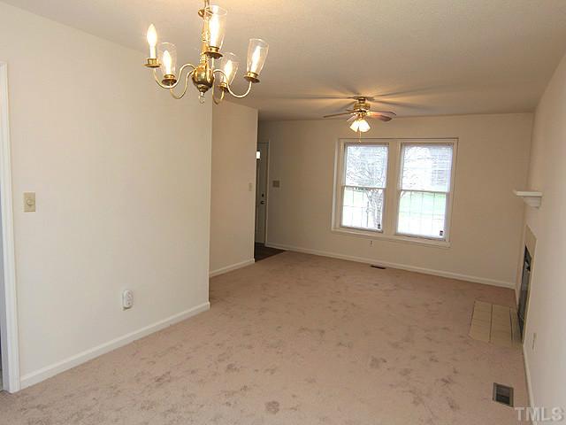 8201 Bellingham Circle Raleigh, NC 27615 - Photo 6 of 22 an empty room with a chandelier fan and windows