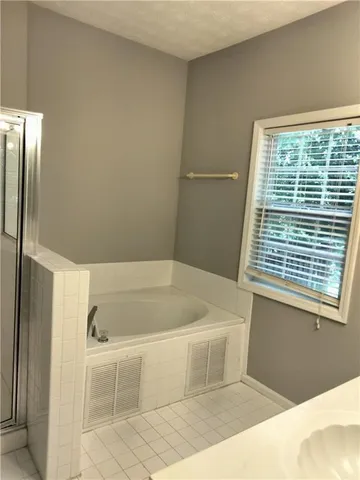 a bathroom with a bathtub and a shower