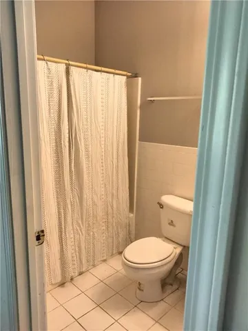 a bathroom with a toilet and a shower curtain
