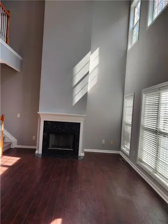 an empty room with windows and fireplace