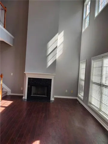 an empty room with windows and fireplace