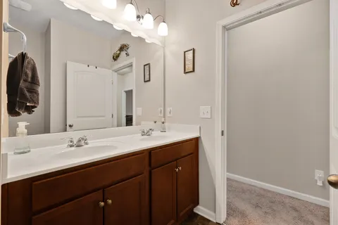 a bathroom with a double vanity sink and a mirror